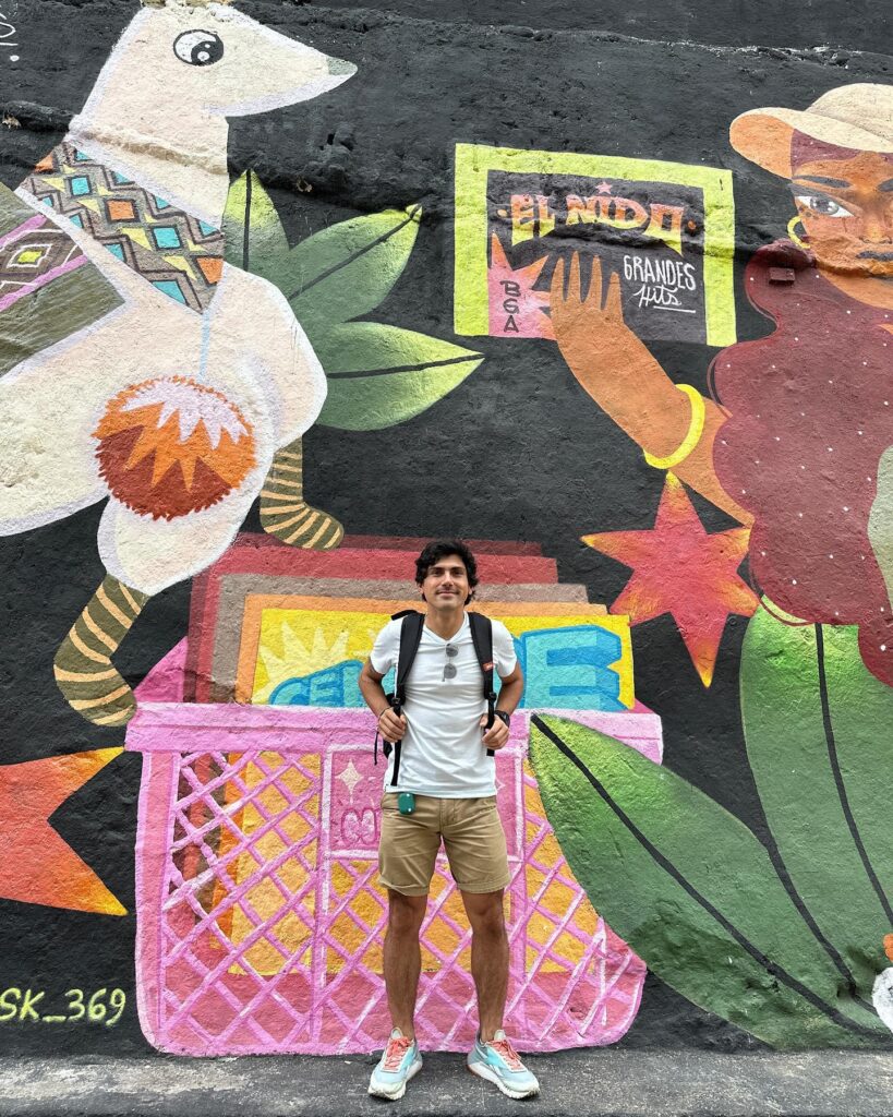 Hombre posando frente a mural urbano El Nido Grandes Artistas
